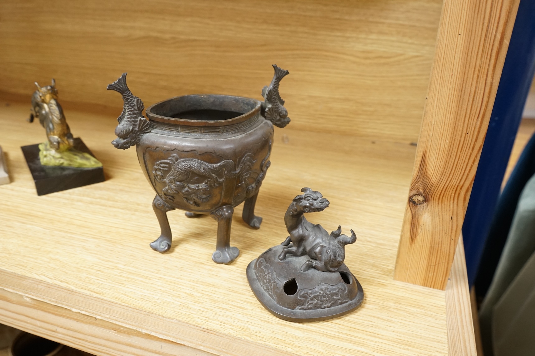 A Japanese bronze koro, raised on four feet with zoomorphic handles and knop, 23cm high